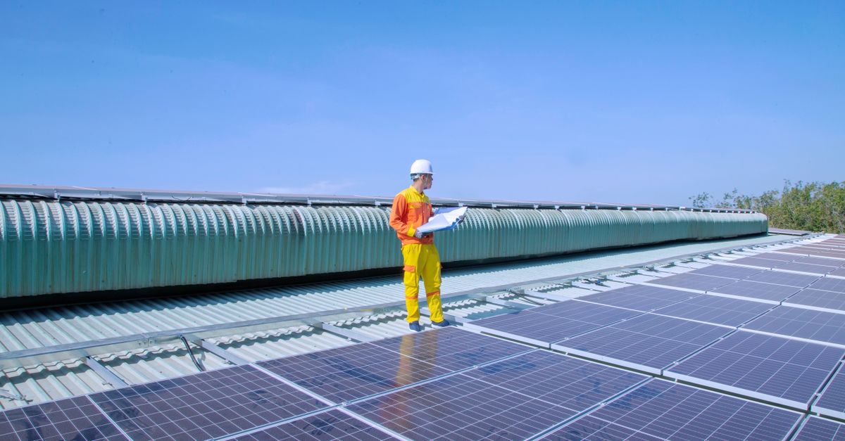 Kỹ thuật viên kiểm tra inverter điện mặt trời trên mái nhà tại TPHCM.